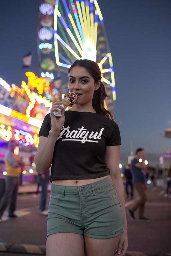 Woman eating a cotton candy at a carnival with a Ferris wheel in the background