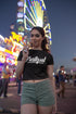 Woman eating a cotton candy at a carnival with a Ferris wheel in the background