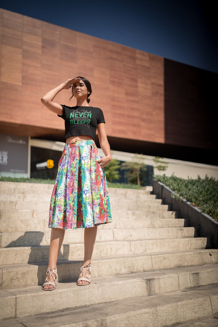 Woman standing on steps wearing a colorful skirt and black top with text.