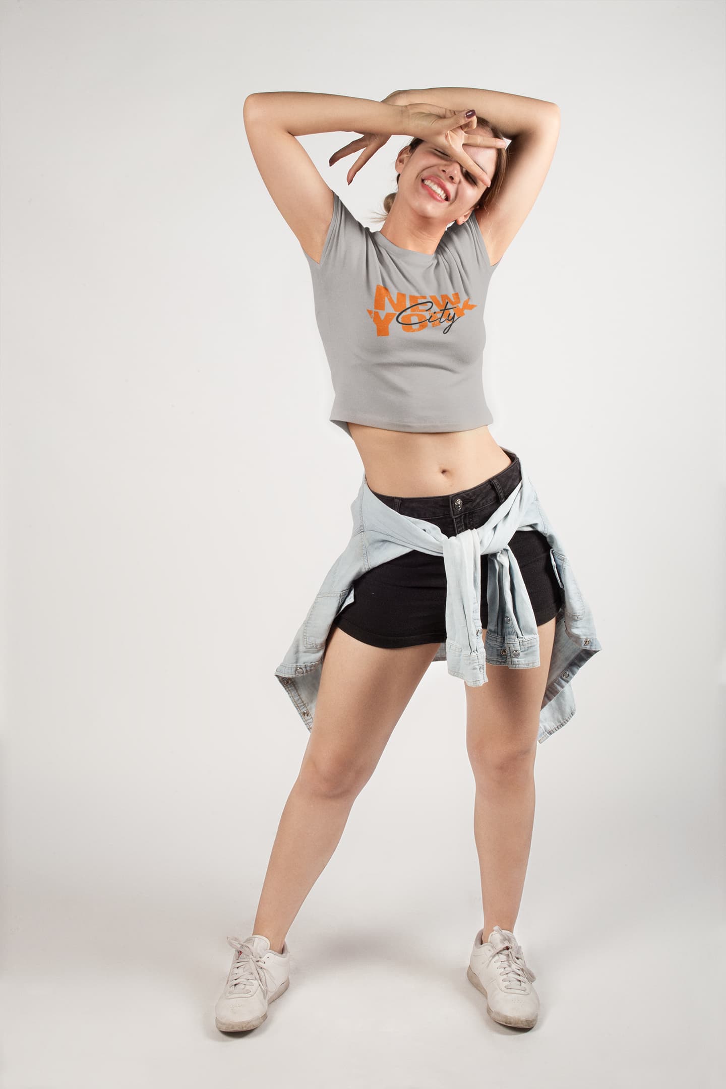 Person wearing a gray sleeveless top with text and black shorts on a white background