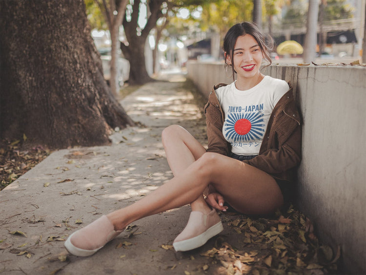 Woman sitting on a sidewalk wearing a &