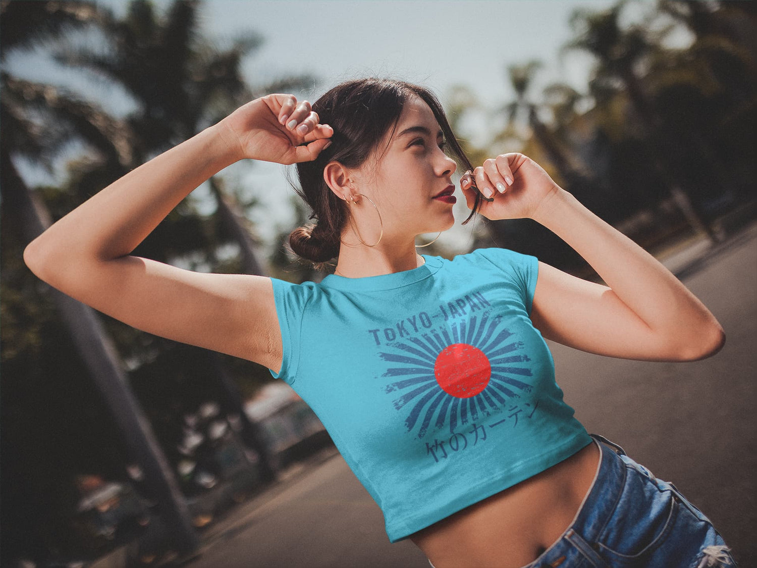 Woman in a blue crop top with a red circle design outdoors