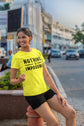 Woman wearing a bright yellow t-shirt with &