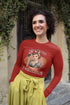 Woman wearing a red shirt with a graphic design and text, standing outdoors.