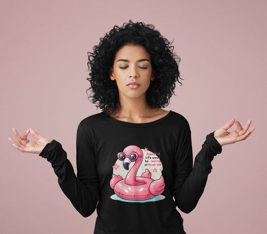 Woman wearing a black long-sleeve shirt with a pink flamingo graphic on a pink background