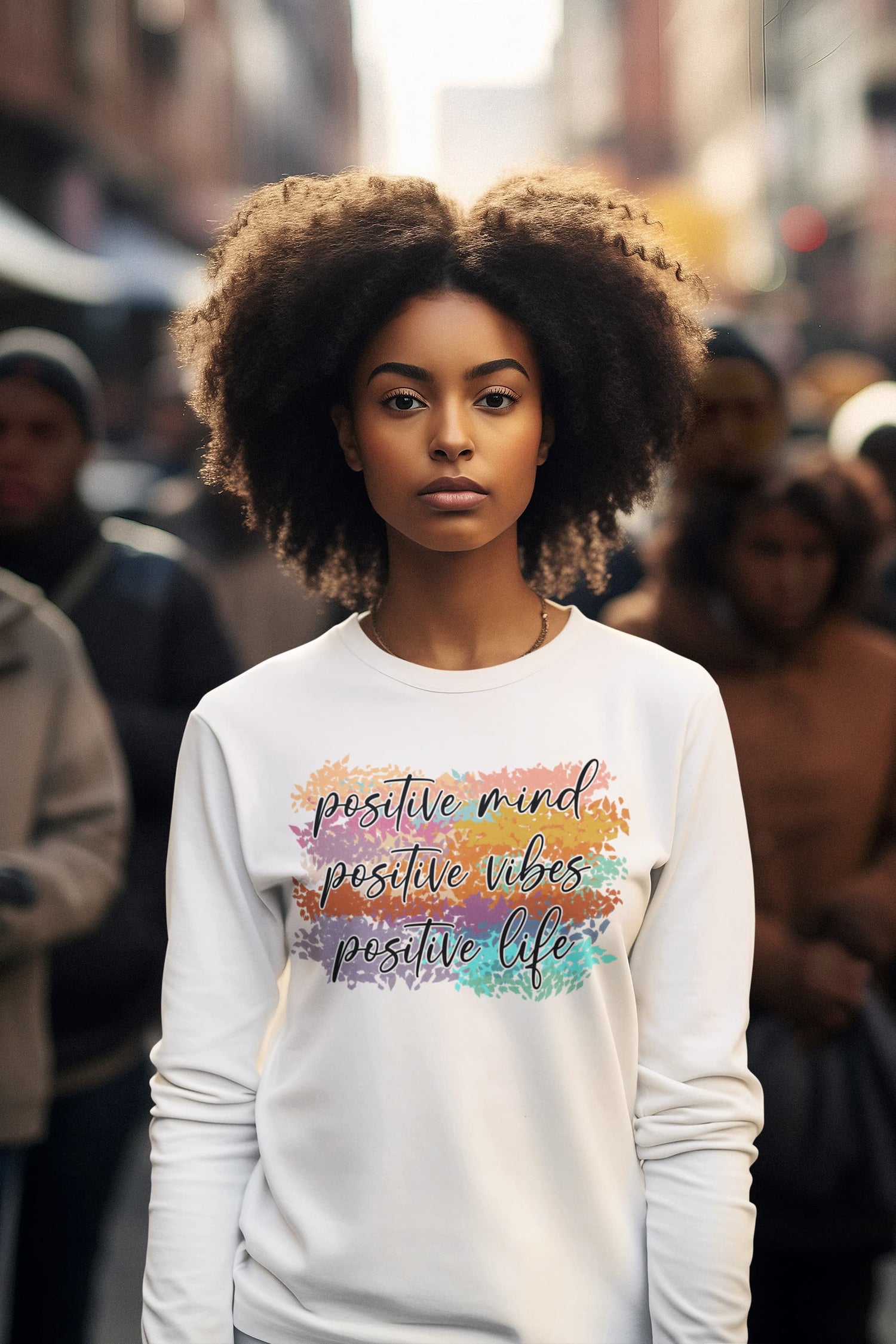 Woman wearing a white sweatshirt with colorful text in an urban setting