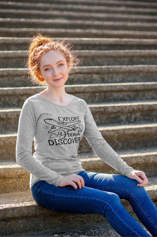 Young woman sitting on steps wearing a gray sweatshirt with text