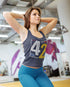 Woman in a gym wearing a tank top with the number 42
