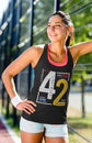 Woman in a gym wearing a tank top with the number 42