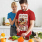 Man and woman in a kitchen preparing food, with the man wearing a red t-shirt with a pie graphic and text.