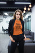 Woman wearing an orange t-shirt with text in a modern office setting