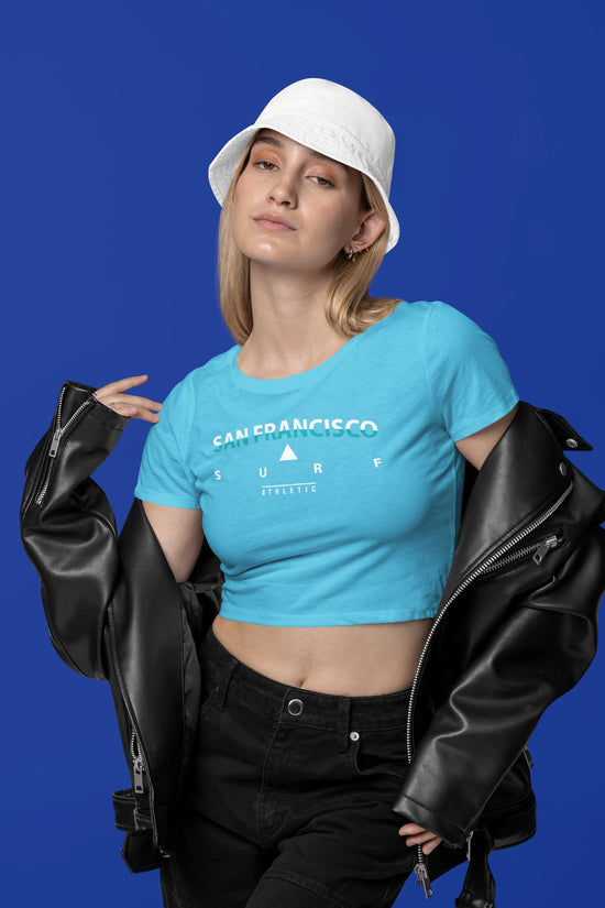 Person wearing a blue t-shirt with text and graphics, holding a black leather jacket against a blue background