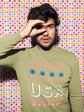 Man wearing a green sweatshirt with &