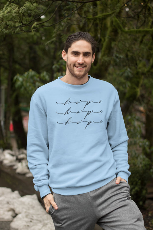 Man wearing a light blue sweatshirt with 'hope' text, standing outdoors.