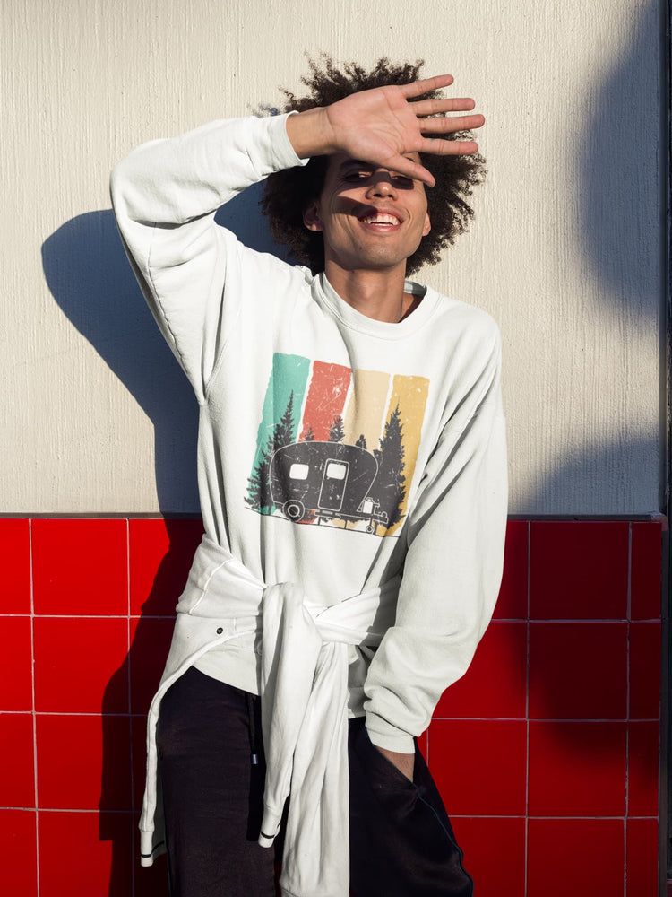 Person wearing a white sweatshirt with a graphic design against a red and beige wall.
