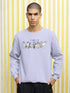 Person wearing a light blue sweatshirt with &