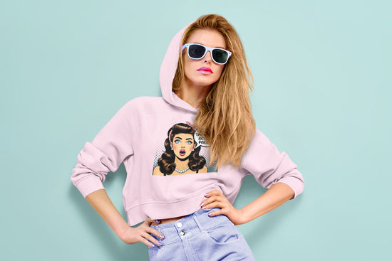 Woman wearing a pink hoodie with a graphic design on a light blue background
