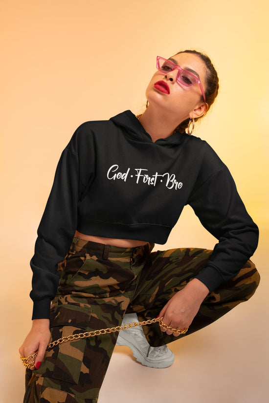 Person wearing a black hoodie with text and camouflage pants on a beige background