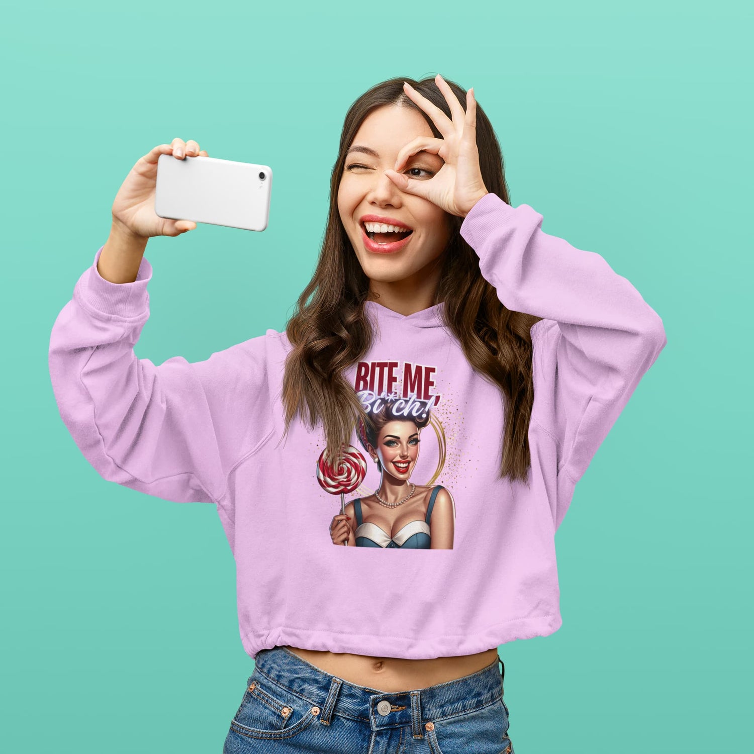 Person wearing a purple sweatshirt with a graphic design on a teal background