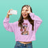Person wearing a purple sweatshirt with a graphic design on a teal background