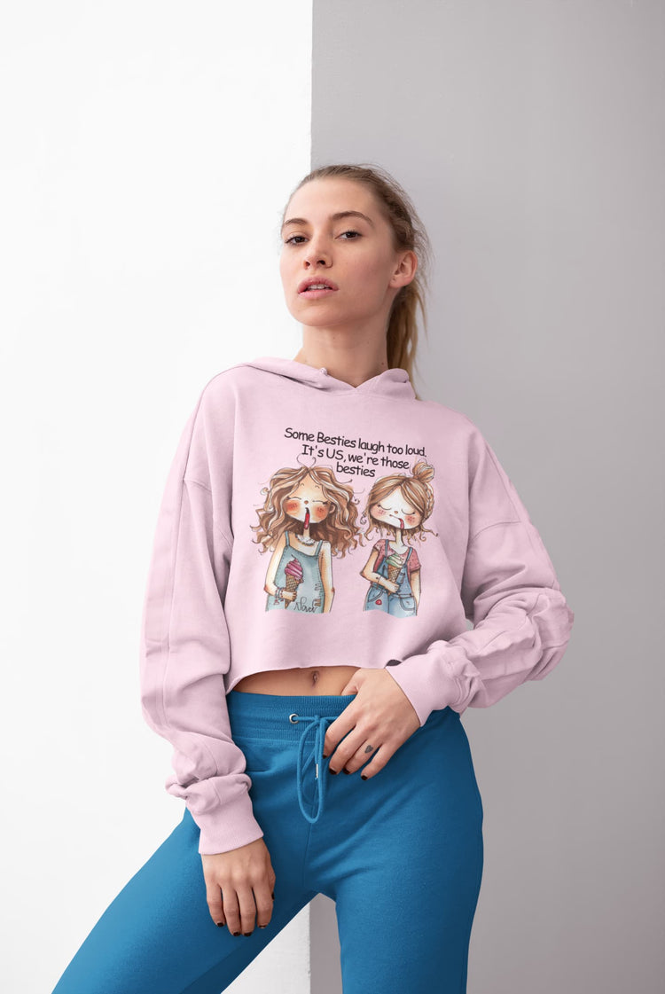 Woman wearing a pink hoodie with cartoon characters and text, standing against a gray background
