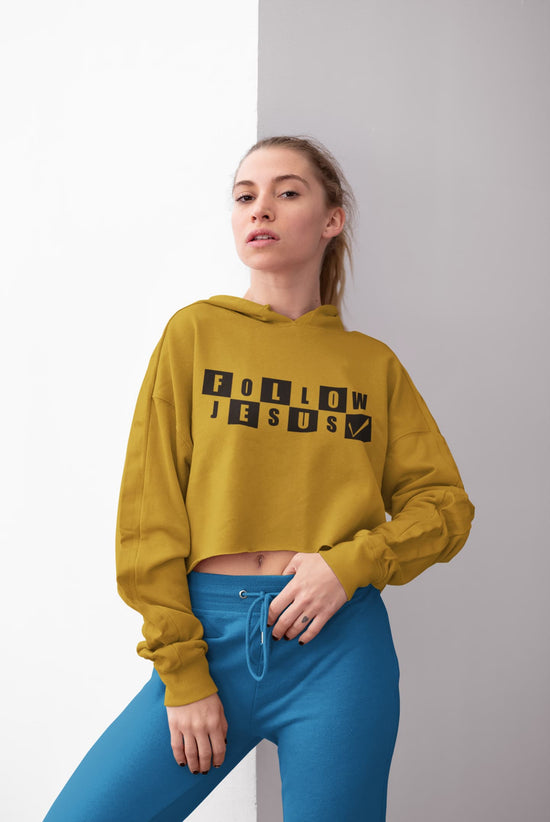 Person wearing a mustard yellow hoodie with &