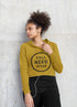 Woman wearing a mustard yellow hoodie with &
