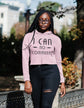 Person wearing a pink hoodie with text, standing outdoors.