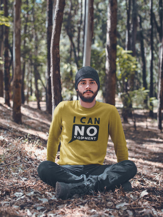 Man sitting in a forest wearing a yellow sweater with text