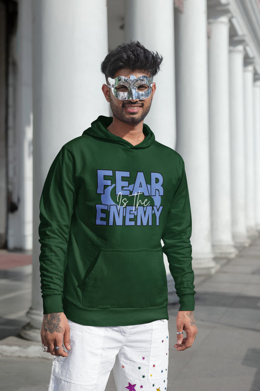 Man wearing a green hoodie with 'FEAR is the ENEMY' text, standing outdoors.
