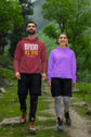 Two people wearing hoodies standing on a trail with a forest background
