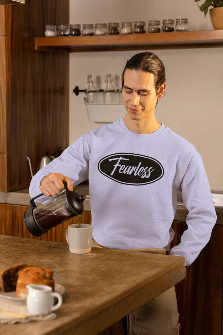Person pouring coffee in a kitchen wearing a sweatshirt with &