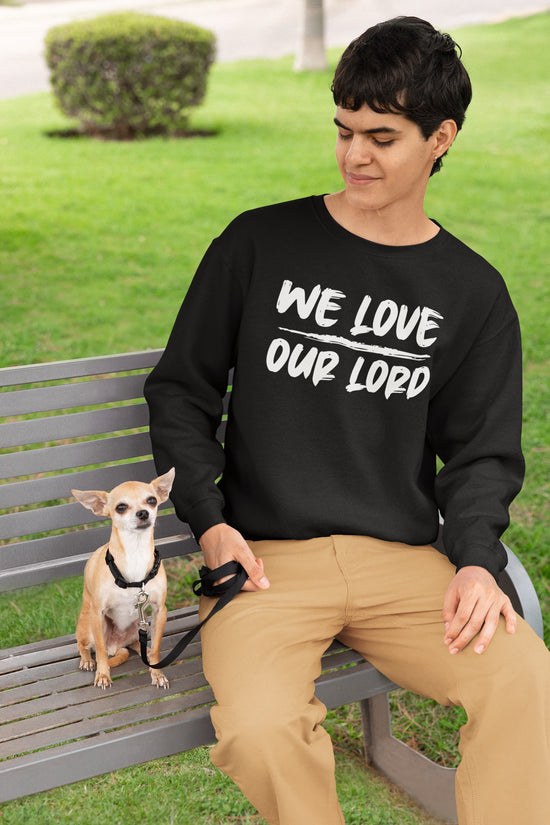Person sitting on a bench with a dog, wearing a black sweatshirt with text, in an outdoor setting.
