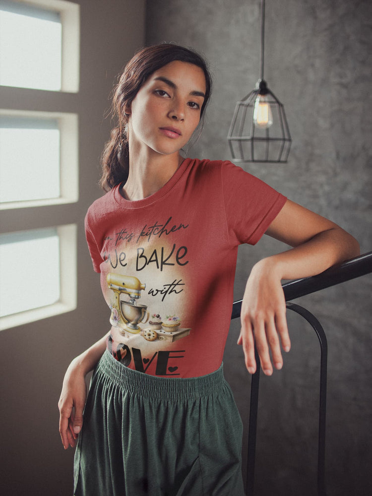 Woman wearing a red t-shirt with a graphic design, standing indoors.