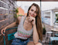 Woman sitting outdoors in a casual setting with a relaxed posture