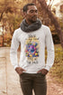 Man wearing a white long-sleeve shirt with a colorful graphic and text, standing outdoors.