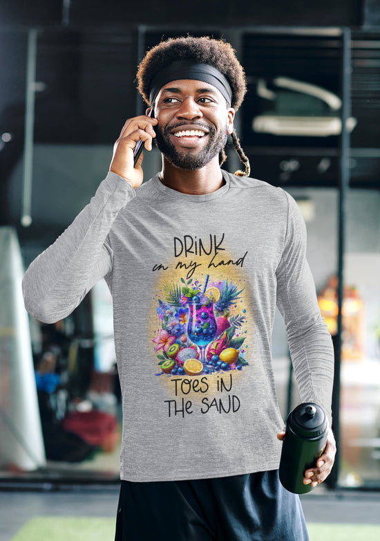 Man wearing a gray sweatshirt with a colorful graphic and text, holding a water bottle and talking on a phone.