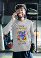 Man wearing a gray sweatshirt with a colorful graphic and text, holding a water bottle and talking on a phone.