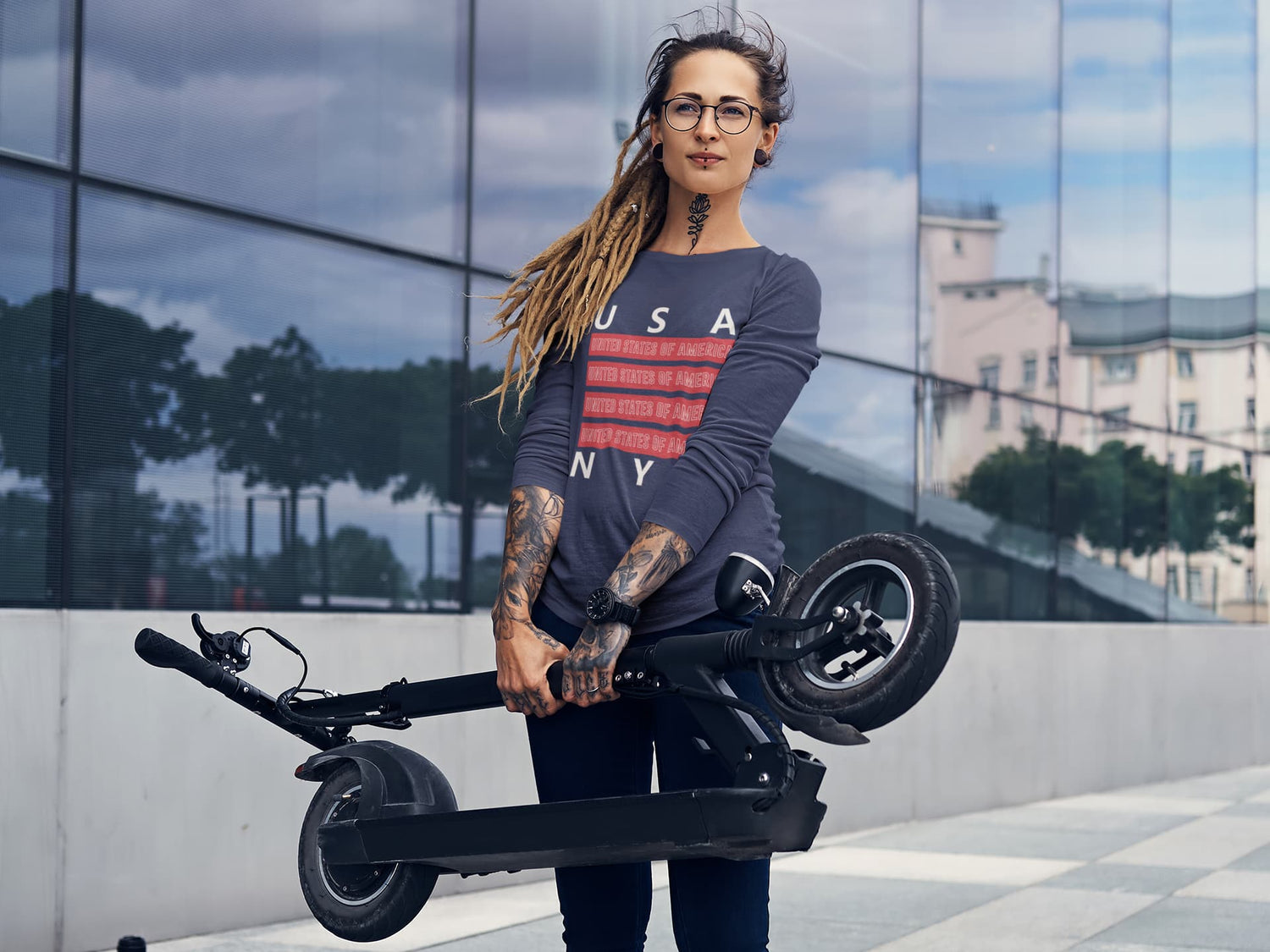 Woman holding a folded electric scooter with a modern building in the background