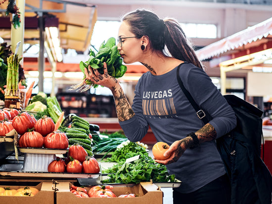 Woman shopping at a farmers market with produce in hand