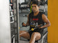 Person exercising on a cable machine in a gym wearing a &