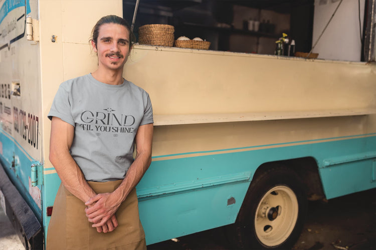 Man standing in front of a food truck wearing a t-shirt with &