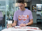 Man wearing a 'Retro Future' t-shirt reading a magazine in a cafe.