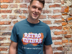 Man wearing a blue t-shirt with 'Retro Future' design against a brick wall.