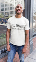 Man wearing a white t-shirt with text standing on a city street.