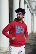 Person wearing a Red hoodie with 'FEAR THE ENEMY' text in front of a graffiti-covered wall.