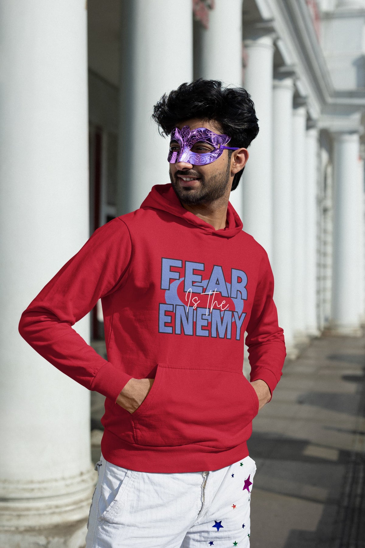 Person wearing a Red hoodie with 'FEAR THE ENEMY' text in front of a graffiti-covered wall.