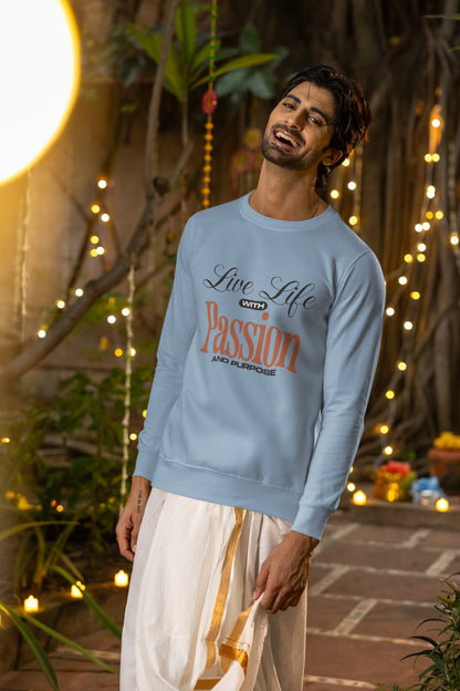 Man wearing a light blue sweatshirt with text, standing in a decorative outdoor setting with lights and plants.