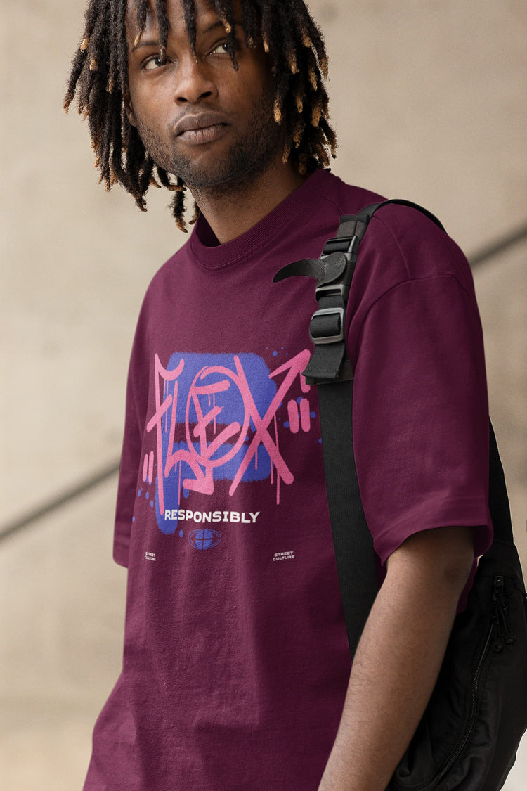 Person wearing a purple t-shirt with a graphic design, standing against a neutral background
