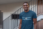Man wearing a blue t-shirt with text standing in an indoor setting